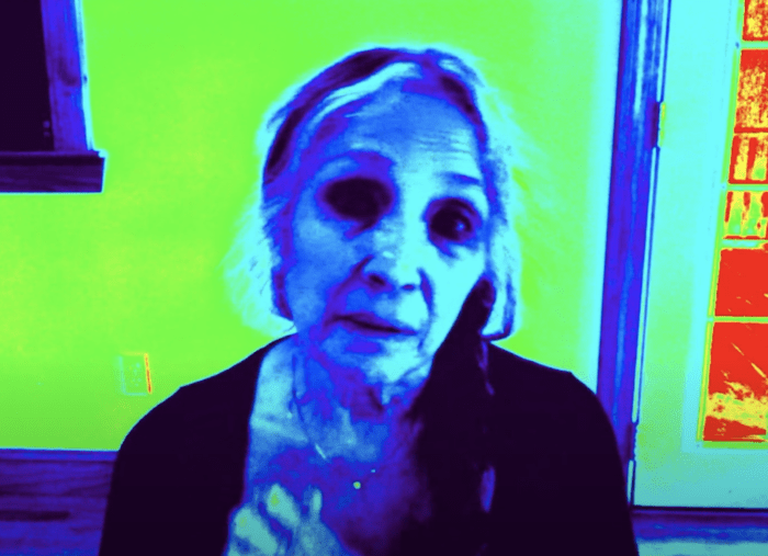 Photoshopped image of an older white woman with white hair. One hand is by her throat and she looks plaintive.