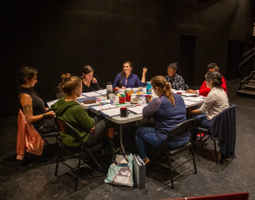 Cast and creative team of KAMLOOPA gathered around the table at their first rehearsal.